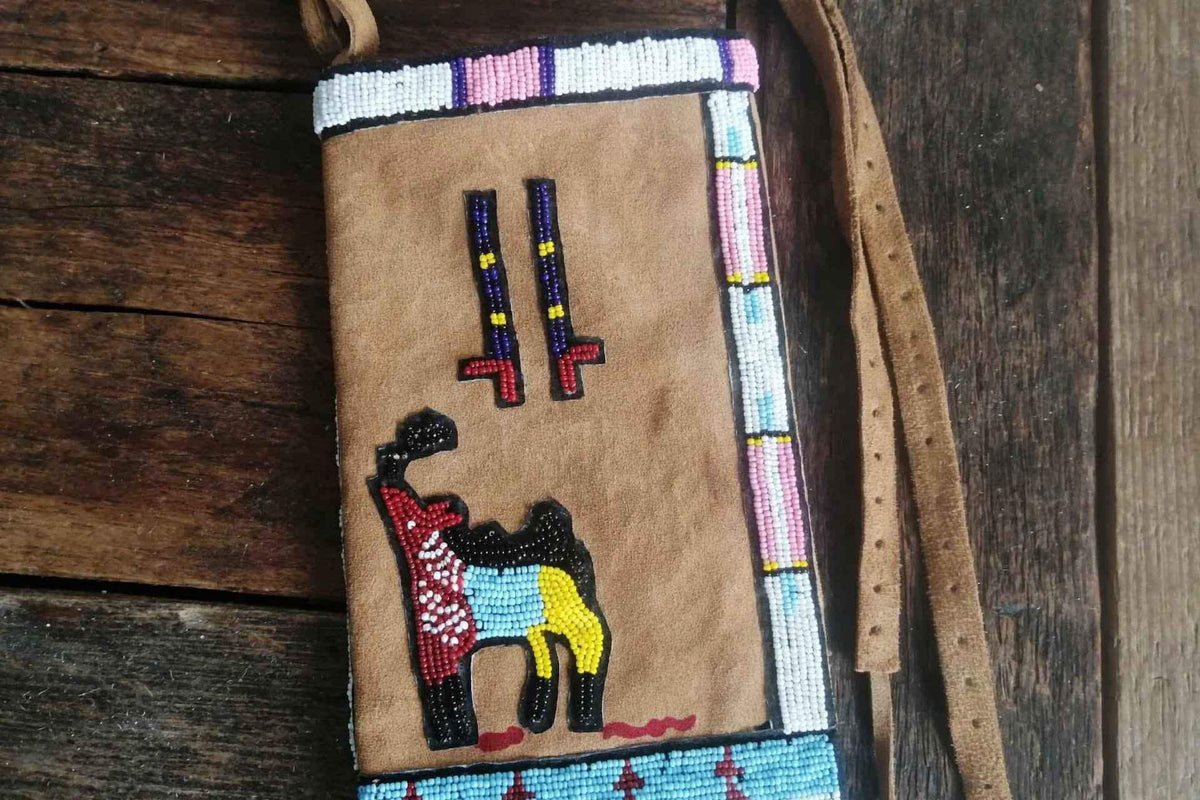 Handmade beaded suede pipe bag with Native American style warrior on horseback design.