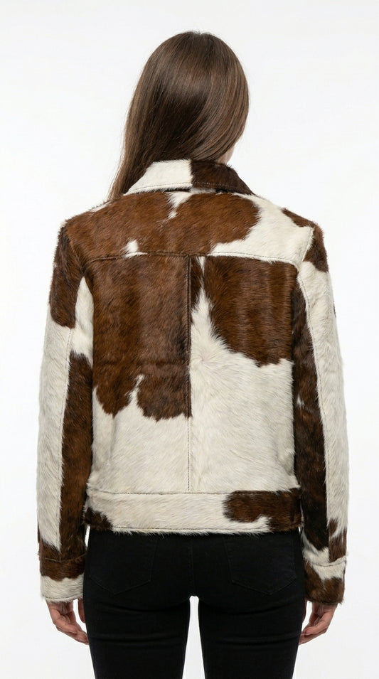 Person wearing a brown and white cowhide leather jacket on a white background
