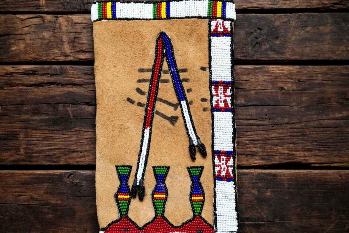 Handmade Native American style beaded suede pipe bag by ZHIM LEATHER CREATIONS on wood background