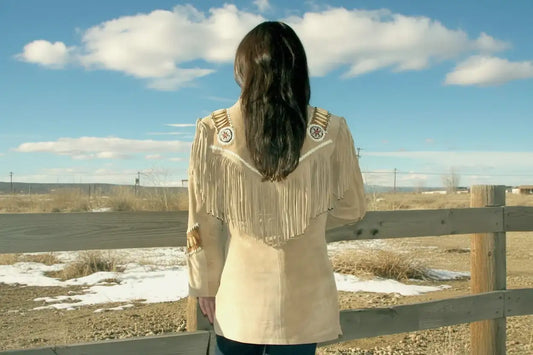 Back view of a woman wearing a Zhim Leather Creations beige suede fringe jacket with beadwork.