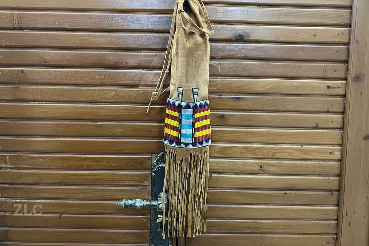 Decorative bag with colorful patterns and fringes hanging on a wooden door.
