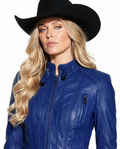 A woman wearing a black cowboy hat and a royal blue leather jacket, photographed against a plain white background.