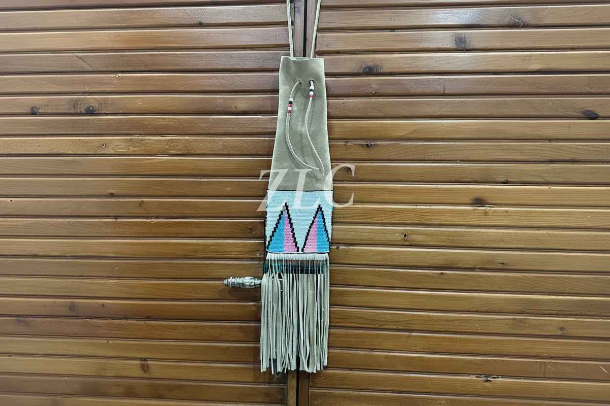 Decorative wall hanging with geometric design and fringes on a wooden background