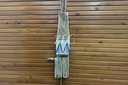 Decorative wall hanging with geometric design and fringes on a wooden background