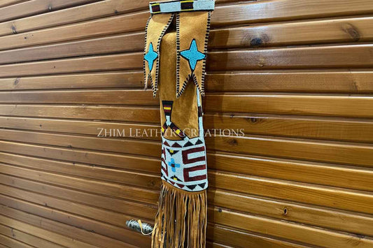 Decorative leather strap with blue and red patterns against a wooden background