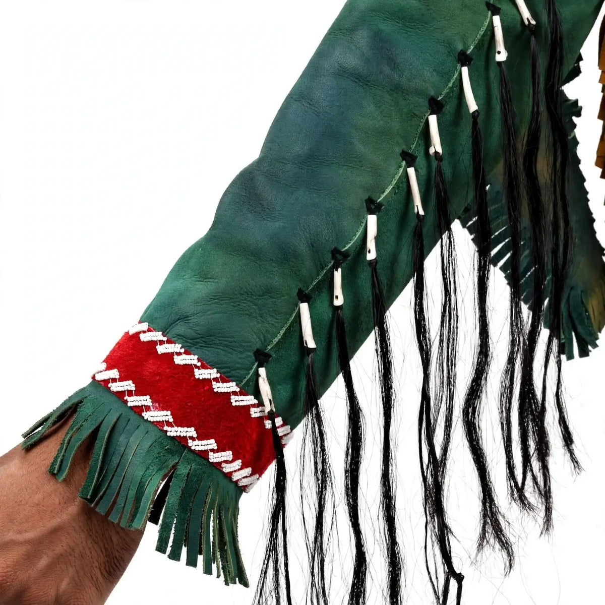 Close-up of a Zhim Leather Creations forest green leather sleeve with red beadwork and black fringe.
