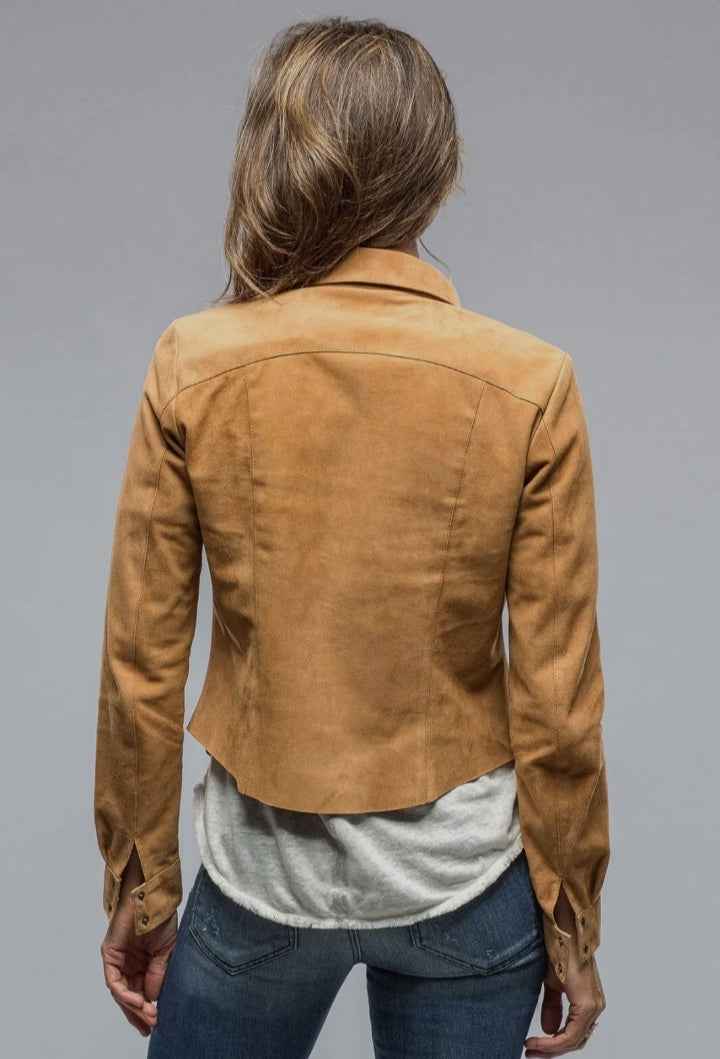 Person wearing a brown suede jacket on a gray background