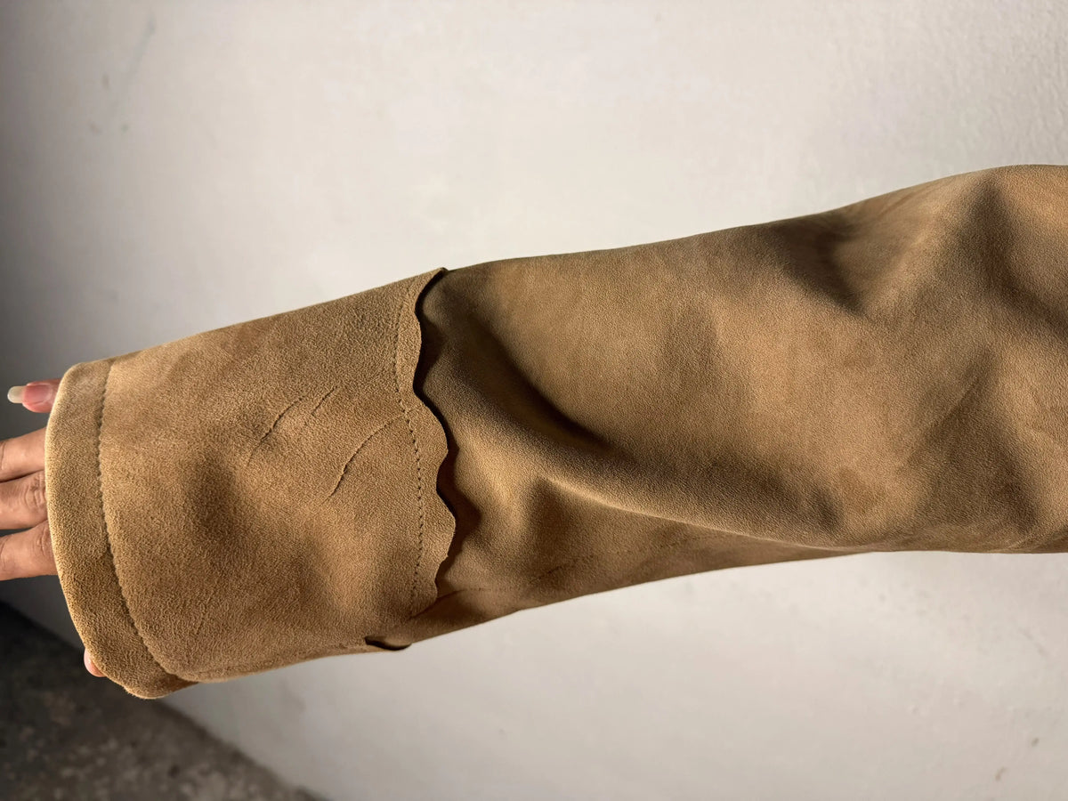 Close-up of the tan buckskin suede sleeve with decorative fringe on a Shane 1953 suit.
