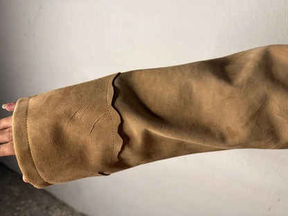Close-up of the tan buckskin suede sleeve with decorative fringe on a Shane 1953 suit.