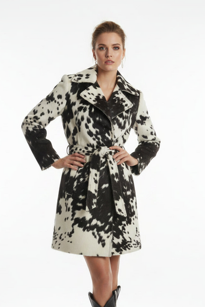 A woman's cowhide print jacket displayed on a mannequin, featuring a striking black and white cow pattern with leather elements.